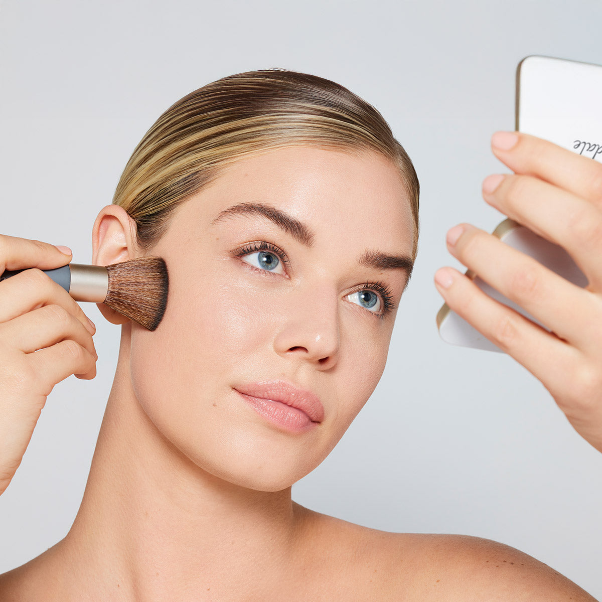 ZEITWUNDER - jane iredale - Ein Model trägt sich mit dem Handi Brush das Pure Pressed Base Mineral Puder im Gesicht auf