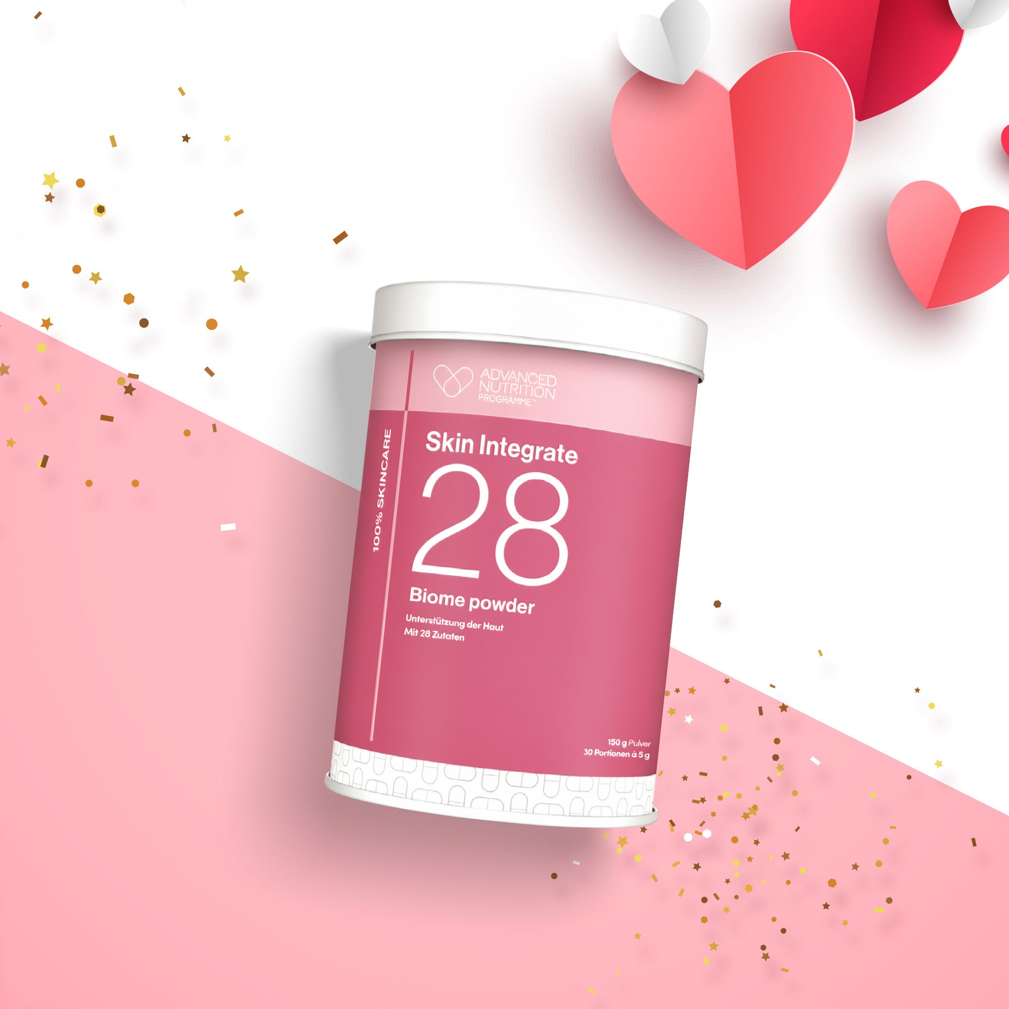 Runde Dose „Skin Integrate 28 Biome Powder“ in Rosa und Weiß mit großer Zahl 28 auf dem Etikett. Die Dose steht auf einem weiß-rosa Hintergrund, umgeben von roten, rosafarbenen und weißen Papierherzen sowie goldenen Konfettipunkten.