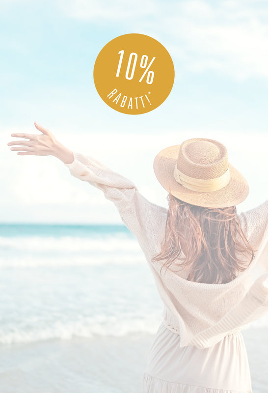 Eine Frau von hinten am Sandstrand mit ausgebreiteten Armen blickt auf das Meer. Sie trägt einen Strohhut und ein helles Sommerkleid. Rechts im Bild ist ein runder, gelber Sticker mit der Aufschrift „10% RABATT*“ zu sehen.